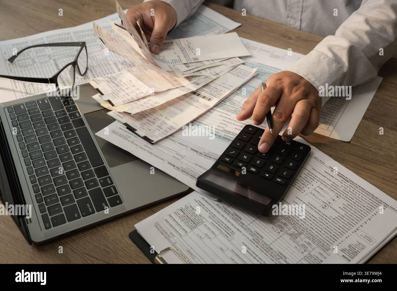Utilizza la calcolatrice con ricevute e documenti finanziari durante l'esecuzione del calcolo delle spese e del processo di pianificazione del budget per la contabilità, financia Foto Stock