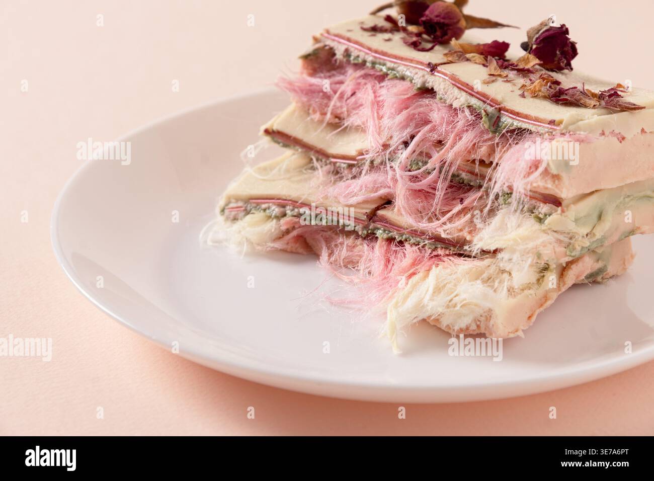 Dessert per capelli d'angelo con texture di caramelle di cotone e petali di rosa secchi, styling artistico per la gastronomia moderna, il branding e i contenuti dei social media. Foto Stock