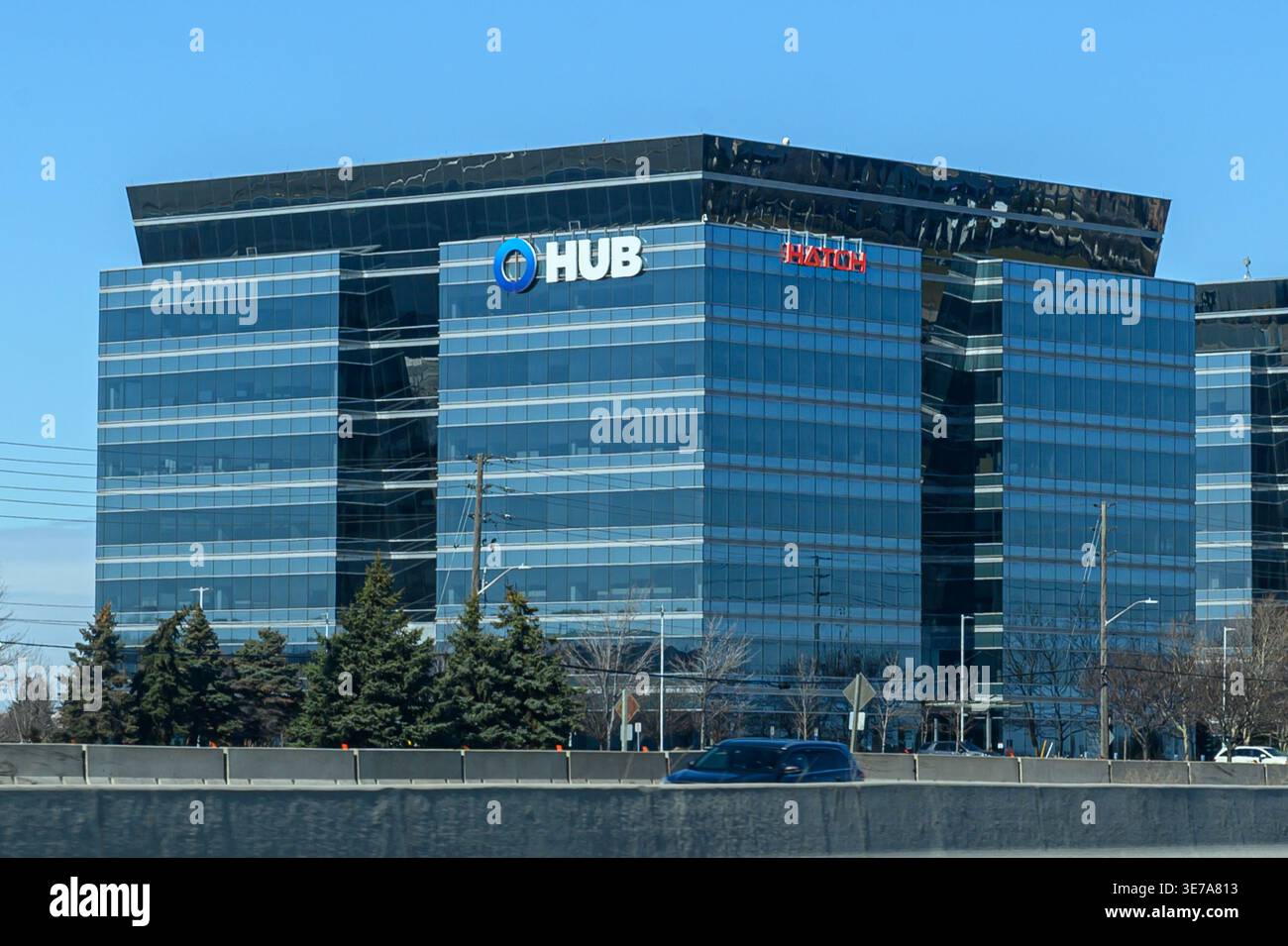 Toronto, ON, Canada - 21 marzo 2026: Vista architettonica della facciata in vetro delle moderne torri per uffici con loghi HUB e PORTELLO nel centro città su un soleggiato viale Foto Stock