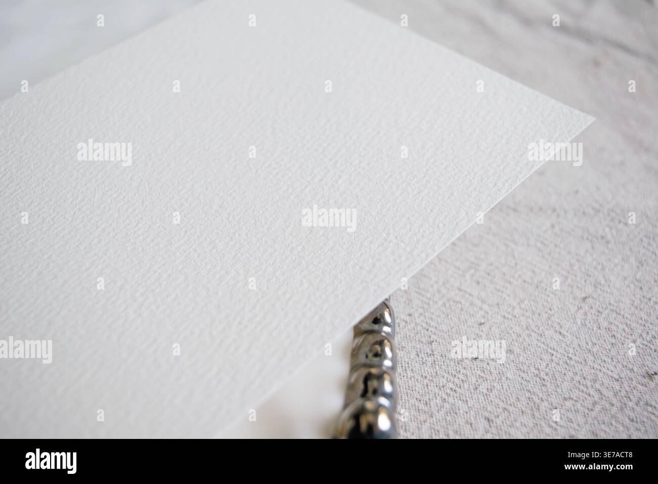 Mockup di carta grezza con catena argentata composizione minimalista di lusso morbido leggero elegante spazio copia modello branding Foto Stock