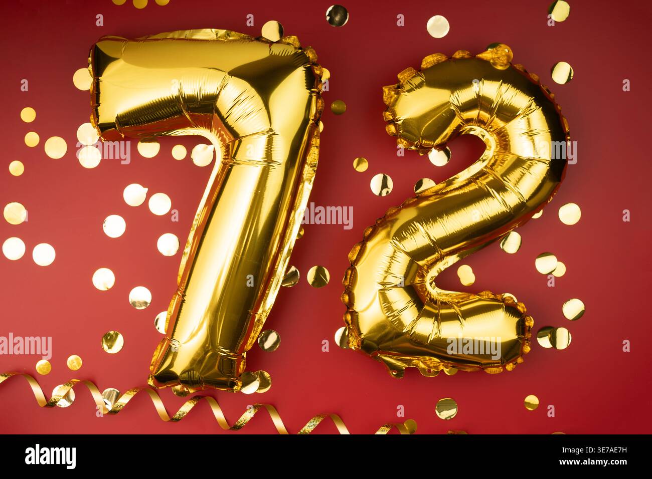 festeggiamenti per il 72° compleanno. I palloncini festivi dorati sono il 72° anniversario su sfondo rosso con coriandoli. Compleanno o matrimonio. Foto Stock
