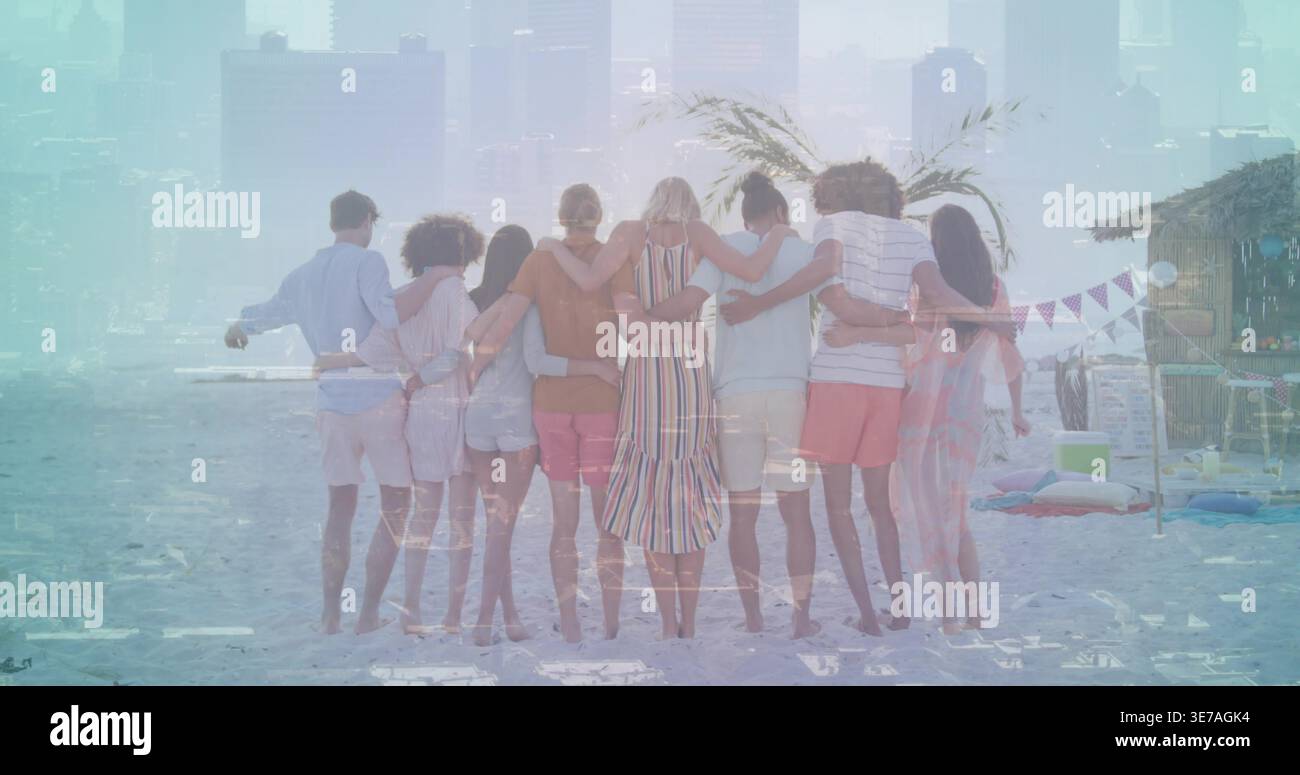 Gruppo in piedi di otto braccia che collegano le braccia e si affaccia sull'oceano in spiaggia, con maxi abito a righe Foto Stock