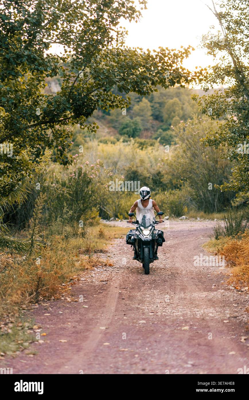 Motociclista avventuroso in bicicletta su strada sterrata attraverso il paesaggio naturale Foto Stock