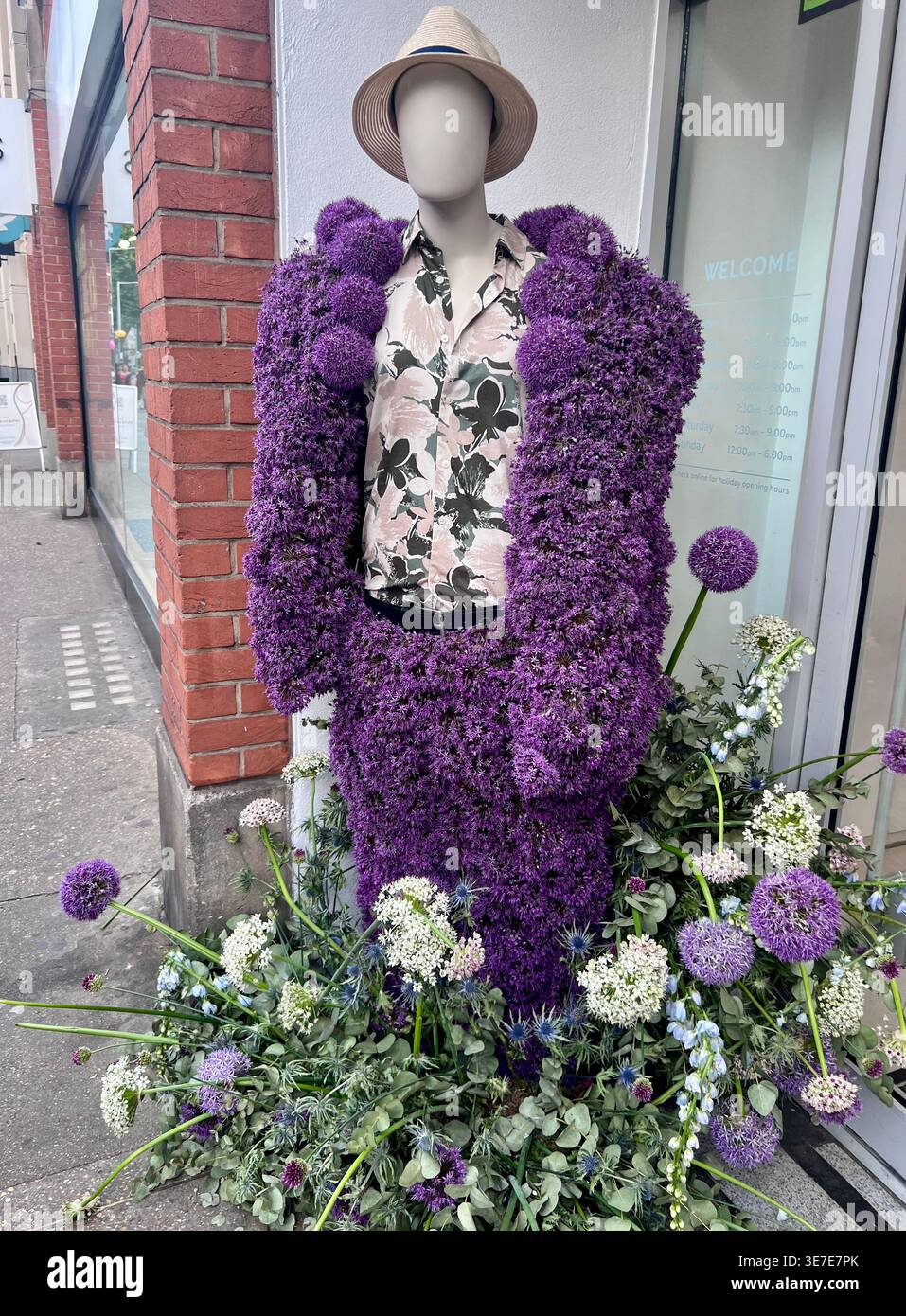 Un manichino maschile vestito con un vestito fatto di fiori, tra cui allium viola e bianco. Foto Stock