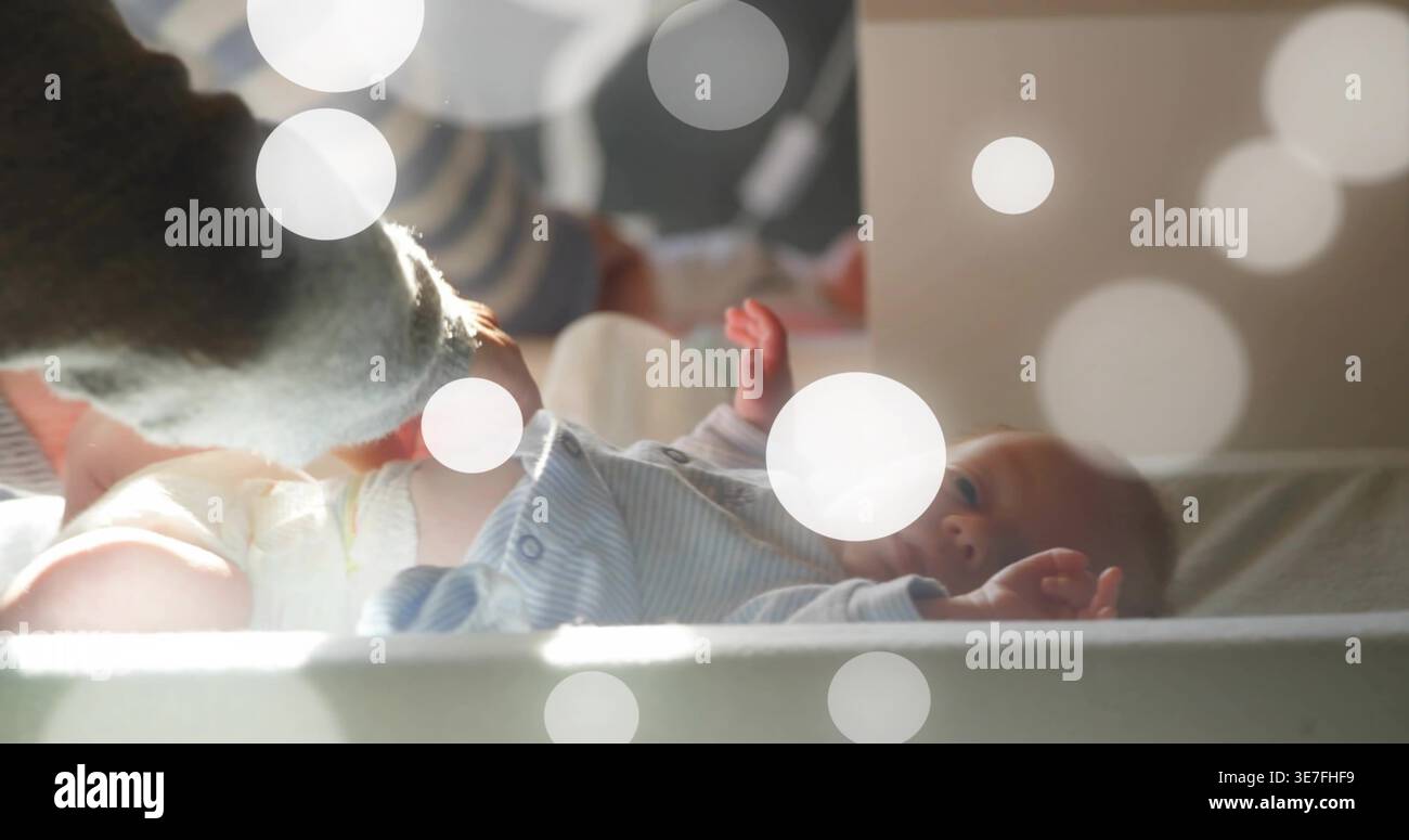 Infermiera donna adulta con bambina che nota il pannolino bagnato sul cuscino nel camerino Foto Stock