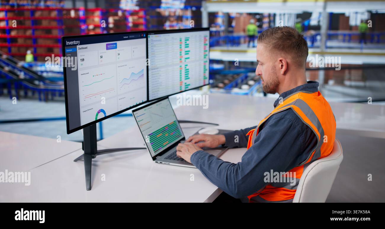 Il supervisore del magazzino analizza i dati di inventario sul computer della workstation Foto Stock