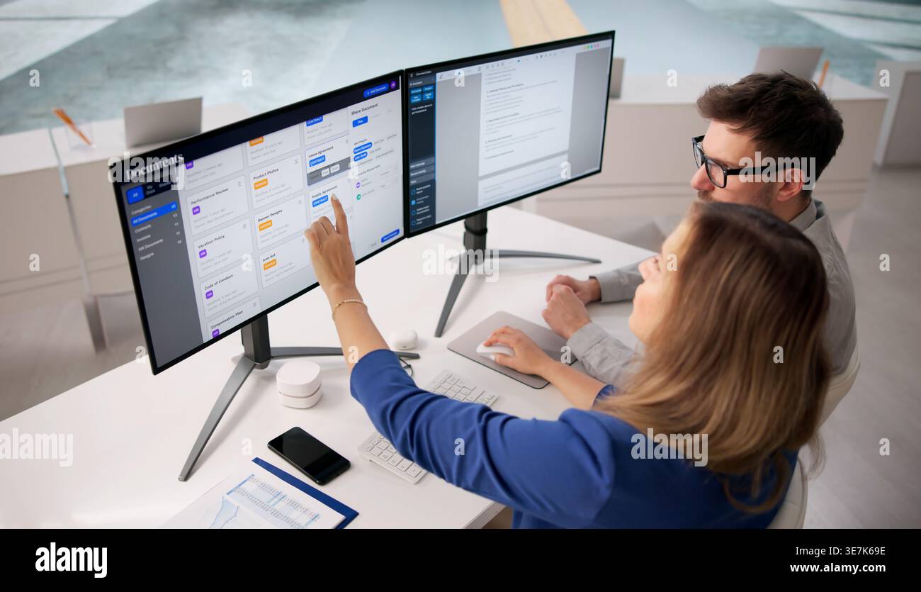 Specialista della sicurezza sul cloud che analizza le registrazioni dei database digitali su Un monitor del computer Foto Stock