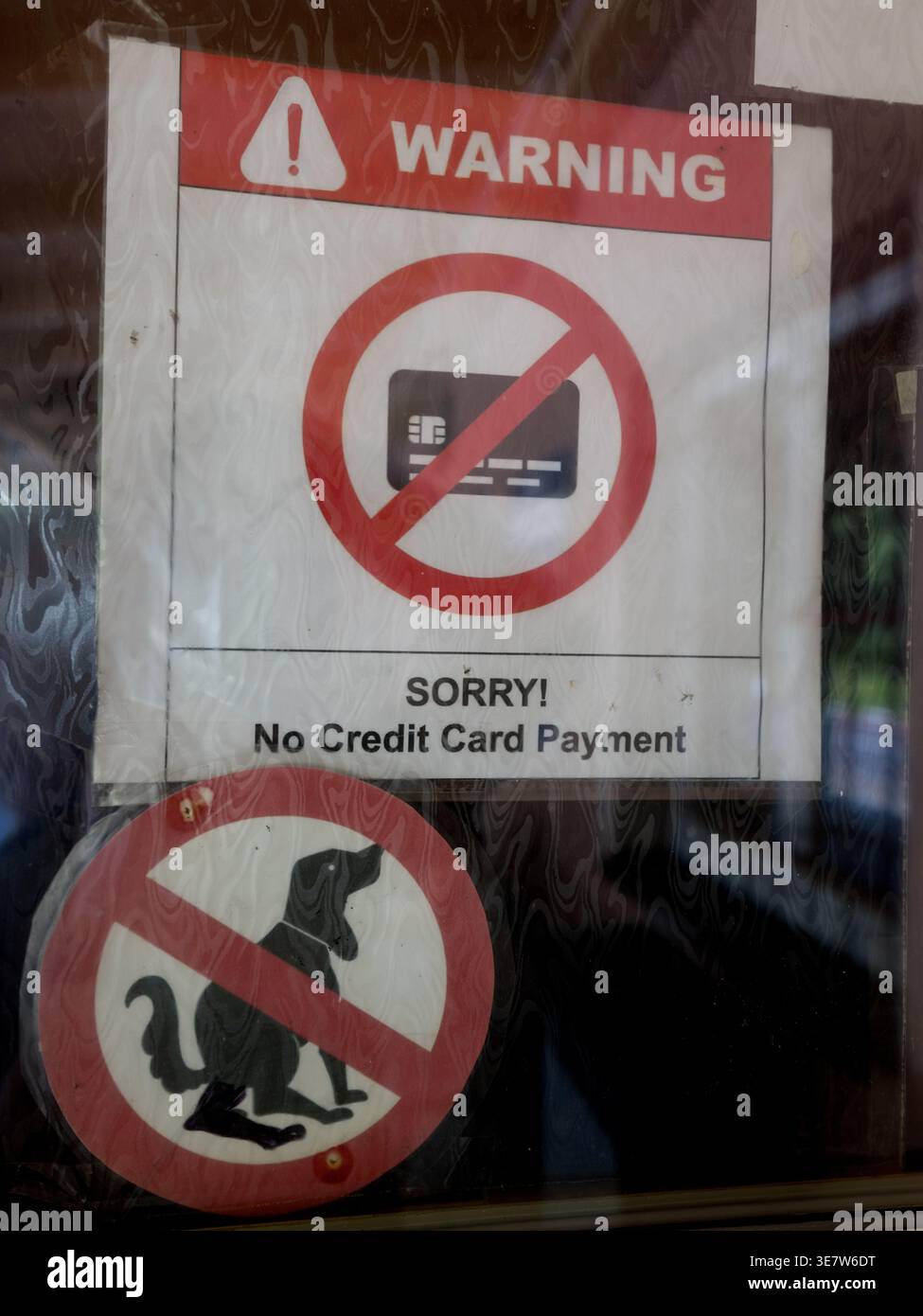 Cartelli segnaletici su una porta di vetro che vietano il pagamento con carta di credito e l'ingresso con cani nella Repubblica Ceca Foto Stock