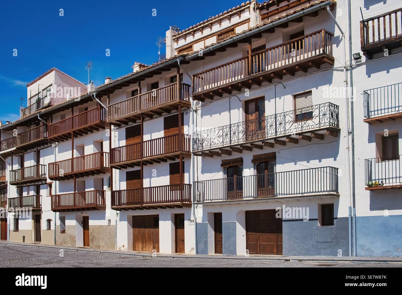 Una fila di edifici storici e tradizionali a più piani in una città spagnola, con intricati balconi in legno e pareti in gesso bianco, a Morella, Catalogna Foto Stock