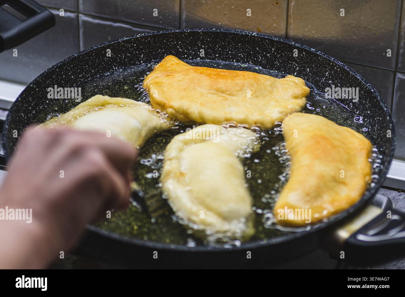 Preparare i panzerotti fritti, un classico Street food pugliese composto da salati salati fatti con impasto per pizza, ripieni di mozzarella e pomodoro, un Foto Stock