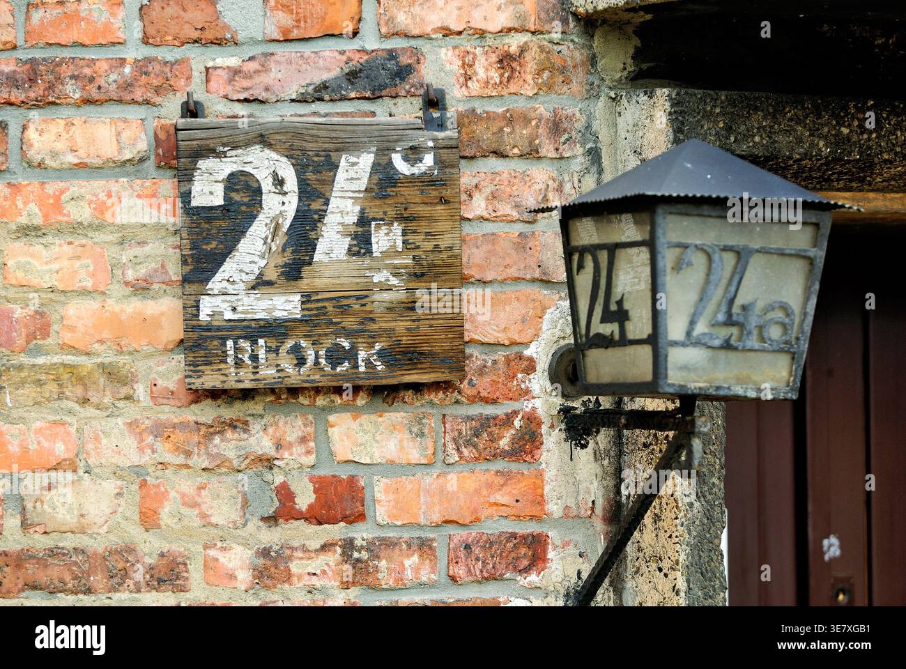 Il blocco 24 si trova al campo di concentramento di Auschwitz a Cracovia. L'area mostra vecchi mattoni e una lanterna contrassegnata con il numero 24. Foto Stock