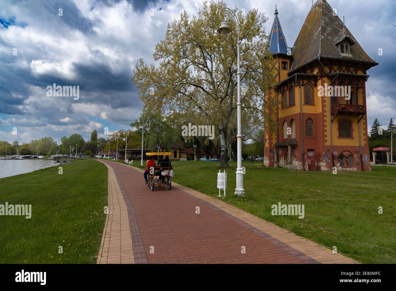 Riverside Path accanto all'Old Colorful Tower Building Foto Stock