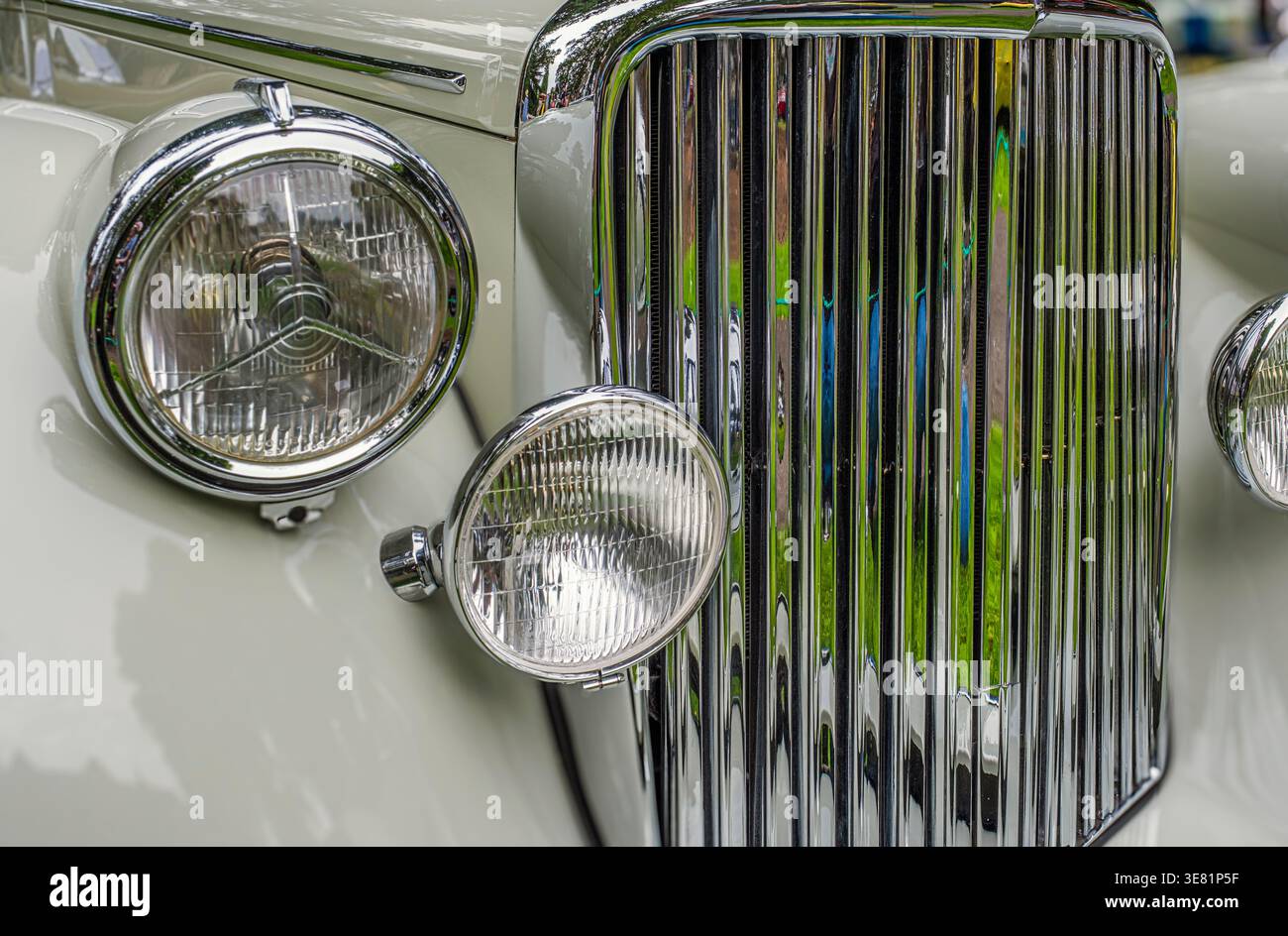 La griglia cromata lucida risplende con eleganza. I fari rotondi riflettono il fascino delle auto d'epoca. Le curve morbide suggeriscono un design classico Foto Stock