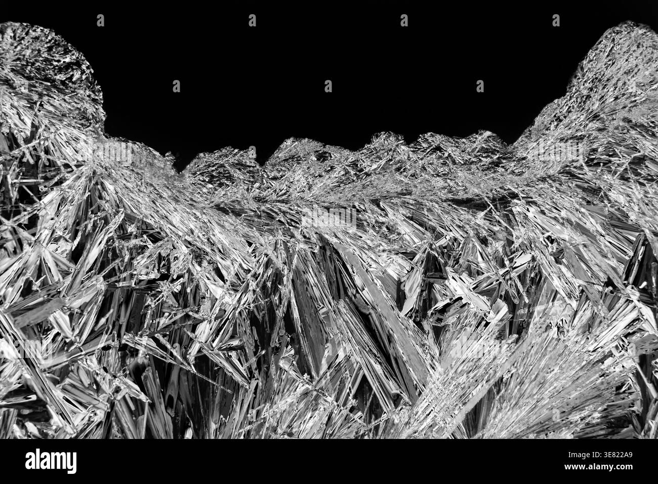 Immagine al microscopio di cristalli di sali di epsom in bianco e nero che danno un drammatico spazio di copia astratto e nero. Foto Stock