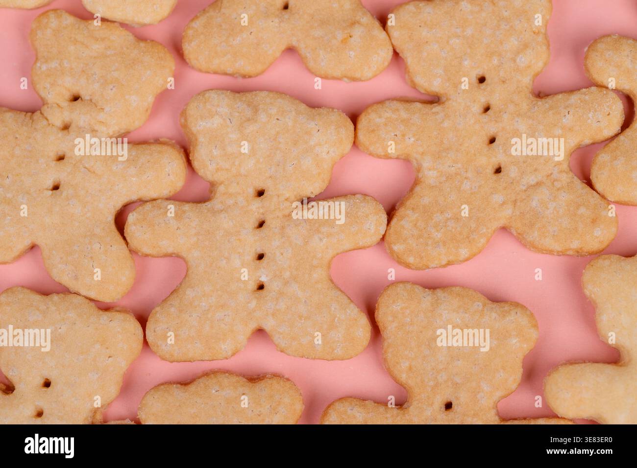 Biscotti con orsacchiotto su sfondo rosa, dettaglio giocoso con scintillio di zucchero e toni caldi, organizzatore della festa che prepara spuntini carini, stylin per i bambini Foto Stock