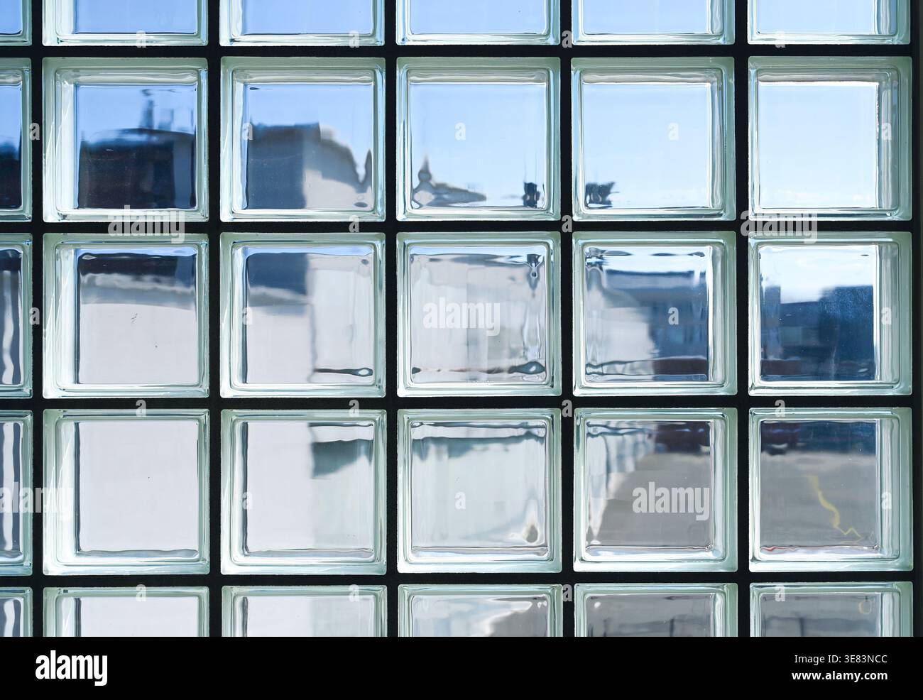 Pulire le pareti dei mattoni di vetro o dei blocchi di vetro con la luce del sole come sfondo Foto Stock