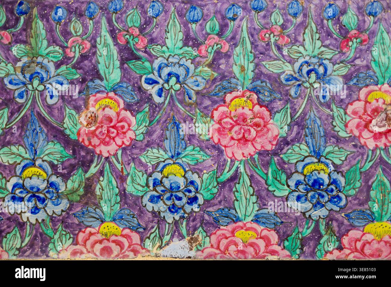 Motivo floreale dipinto a mano con fiori blu e rosa stilizzati e foglie verdi su sfondo viola testurizzato, motivo ornamentale a ripetizione, vintage Foto Stock
