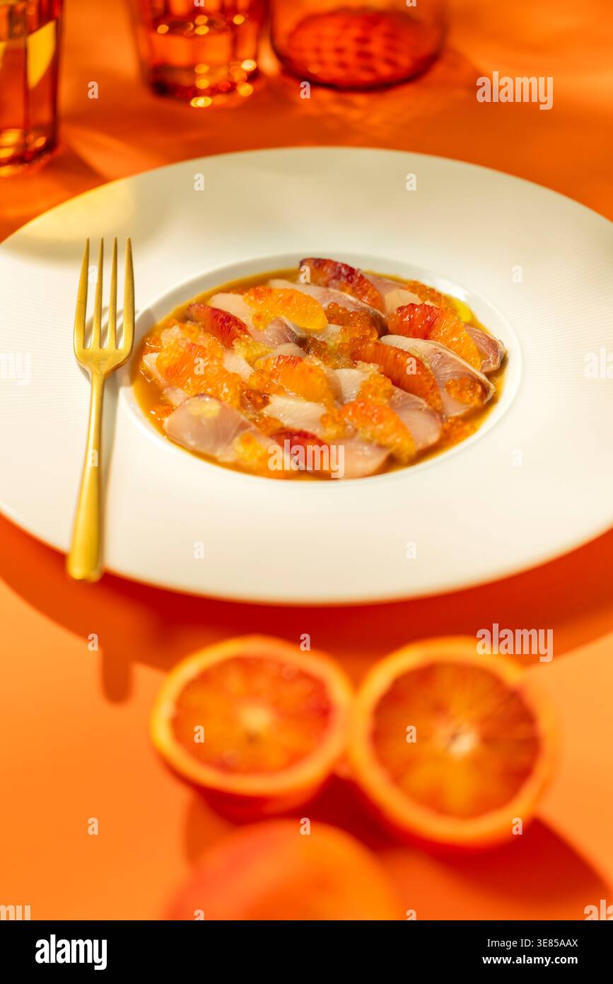 Fette di pesce crudo con segmenti di arancia rossa e uova, per una delizia culinaria fresca Foto Stock