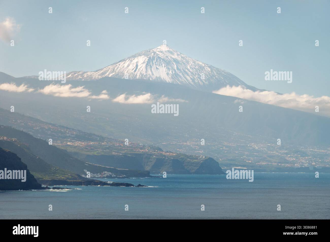 Vista panoramica del monte Teide che si innalza sopra la costa settentrionale di Tenerife, vista da El Pris con le acque dell'Atlantico, le scogliere e le morbide nuvole, che mostrano le Canarie Foto Stock