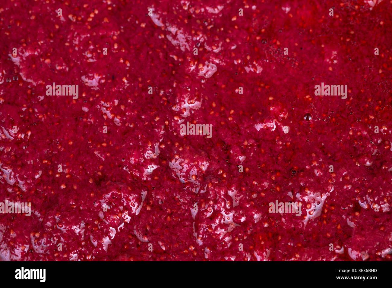 Fragole fresche tritate rustiche schiacciate in marmellata, consistenza spessa e lucida, semi visibili e tasche sciroppate, segni a cucchiaio, conserva l'umore artigianale Foto Stock