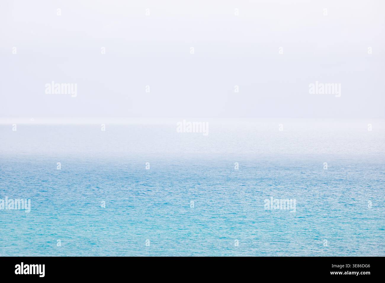 Una fotografia minimalista che raffigura il Mar Mediterraneo blu vicino a Villajoyosa. La scena è dominata da un gradiente netto e definito dove il wa blu Foto Stock