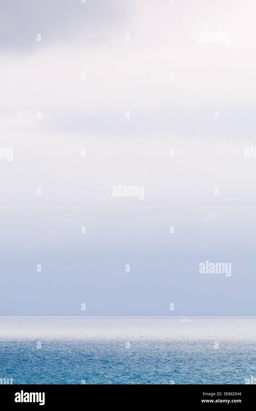 Una foto potente e lunare che si concentra sui colori blu profondi e saturi del Mar Mediterraneo al largo di Villajoyosa. La scena è incorniciata da una pesante Foto Stock