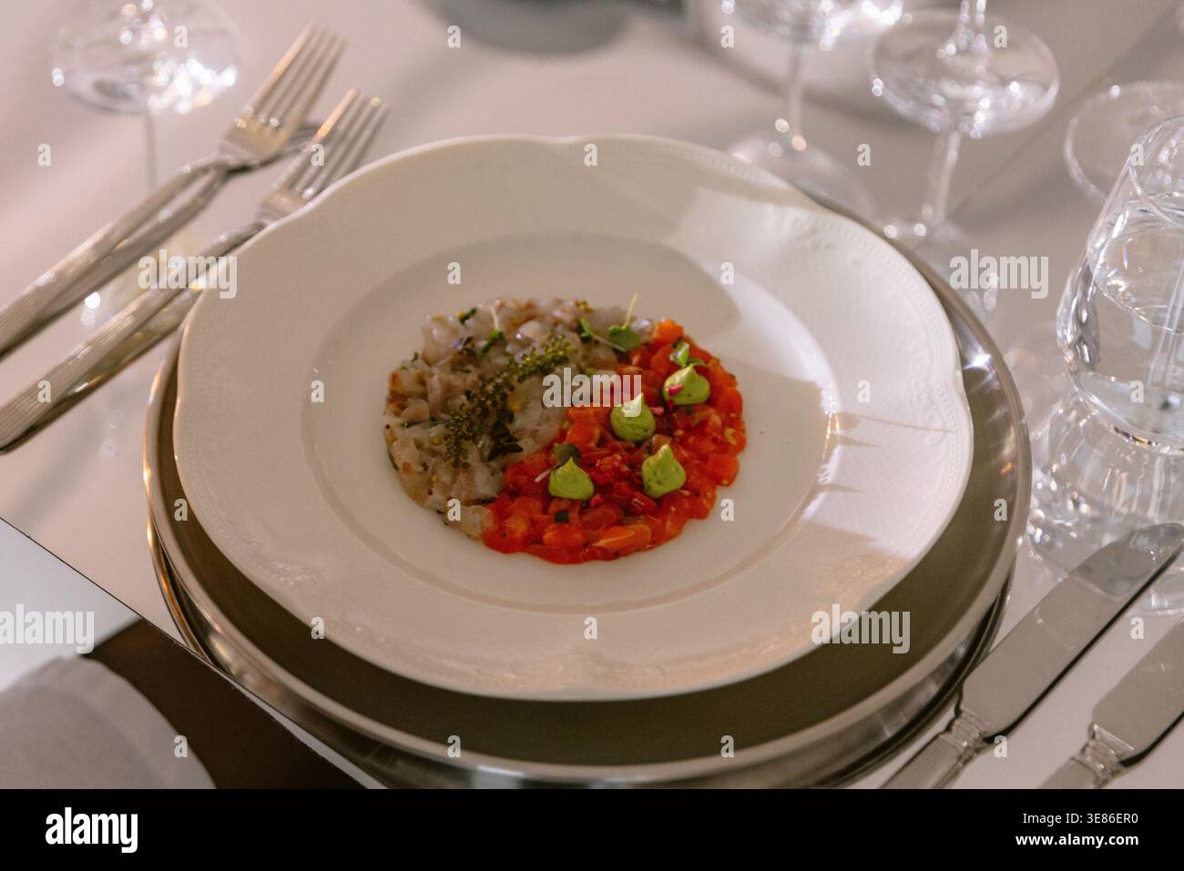 Antipasto gourmet con tartare di pesce servito su un piatto elegante e raffinato ambiente da tavola del ristorante Foto Stock
