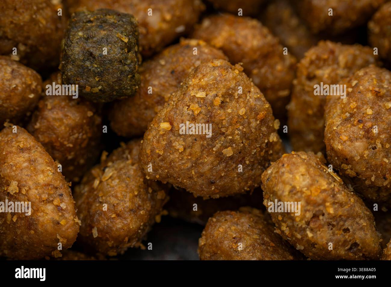 Foto macro di kibble di cibo per cani testurizzato con diversi colori e texture mescolati insieme mostrando pezzi singoli Foto Stock