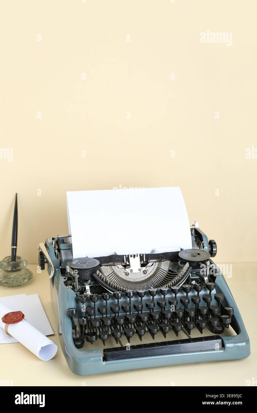 Macchina da scrivere vintage, porta penna e rotolo con sigillo in cera su sfondo beige Foto Stock