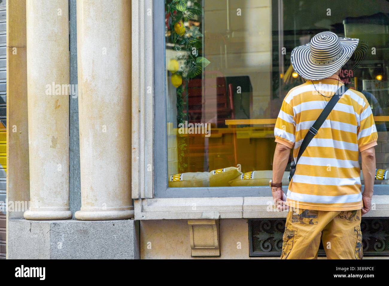 Turista alla ricerca di un ristorante nel centro di Madrid durante le vacanze estive Foto Stock