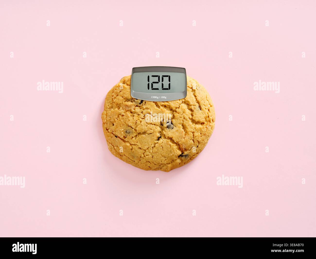 Biscotti con display digitale che mostra il conteggio delle calorie su sfondo rosa, cibo ad alto contenuto calorico, dipendenza da zucchero e l'impatto degli spuntini sul peso corporeo. Foto Stock
