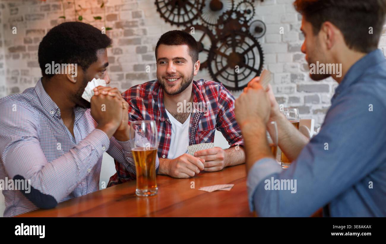 Migliori amici giocando a carte, avente il resto in bar Foto Stock