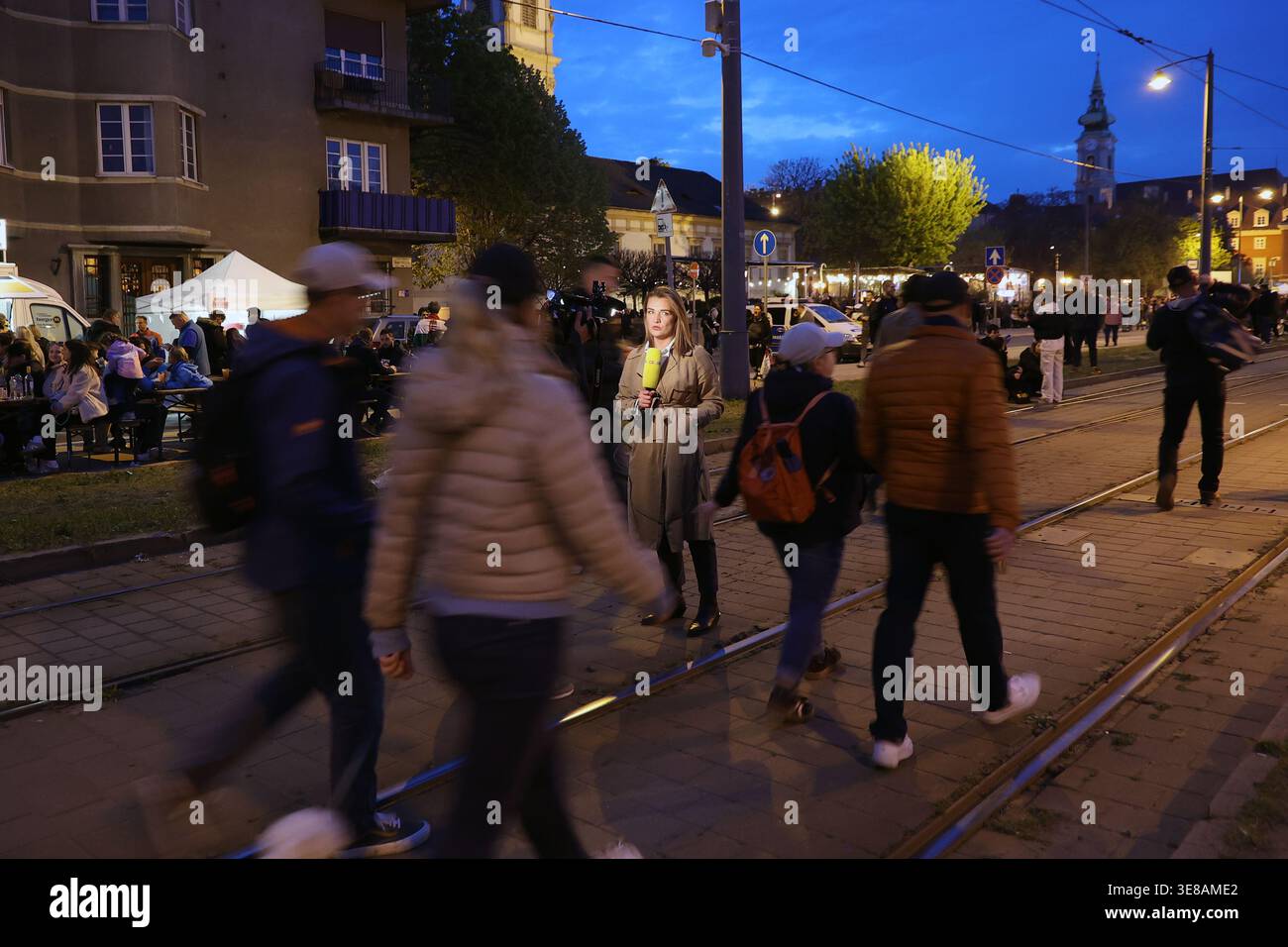 Il giornalista sta riportando per le strade di Budapest, Ungheria, la notte delle elezioni parlamentari del 2026 tra la folla celebrante Foto Stock