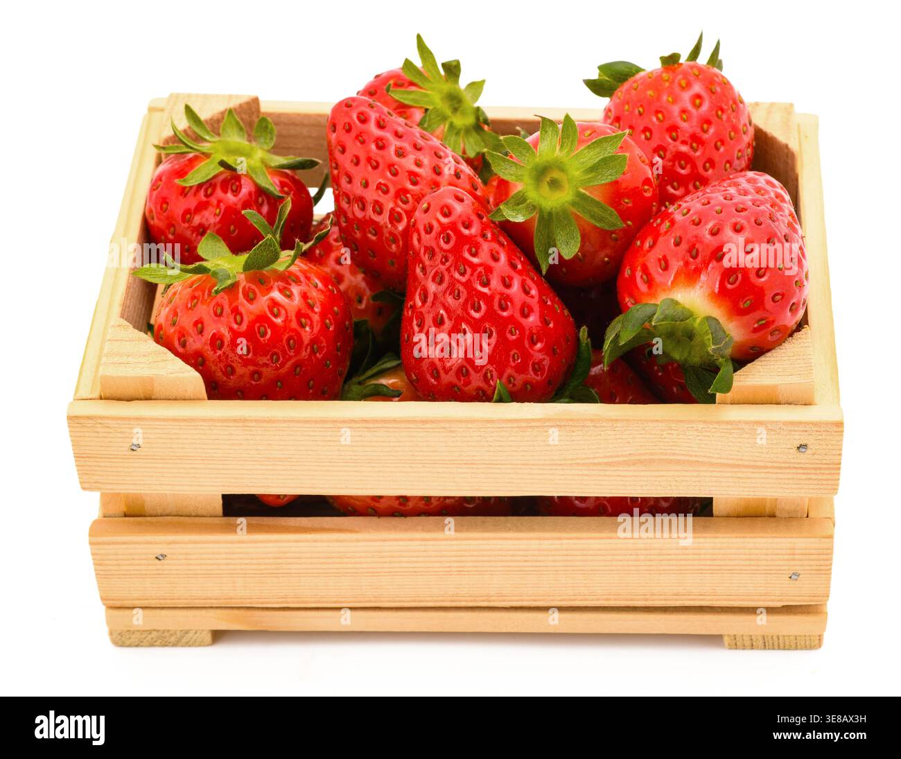 Cassa di legno riempita di fragole fresche mature, isolata su fondo bianco. L'immagine evidenzia il colore naturale, rosso vivace e la freschezza Foto Stock