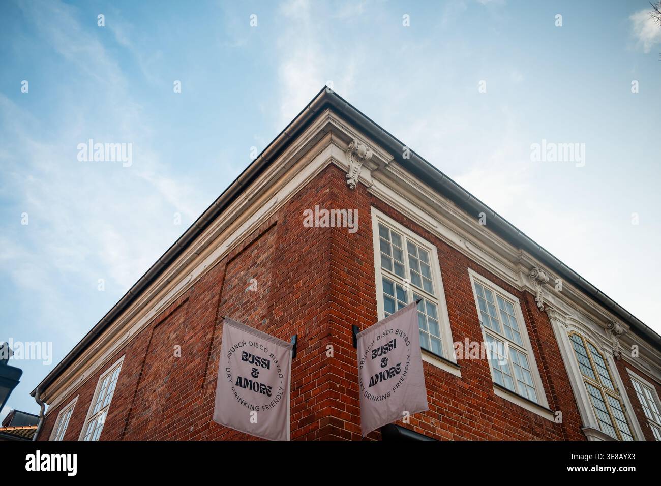 Bussi & amore Bistro nello storico quartiere olandese. Immagine ad angolo basso della facciata in mattoni rossi del bistro Bussi & amore con bandiere bianche. Foto Stock