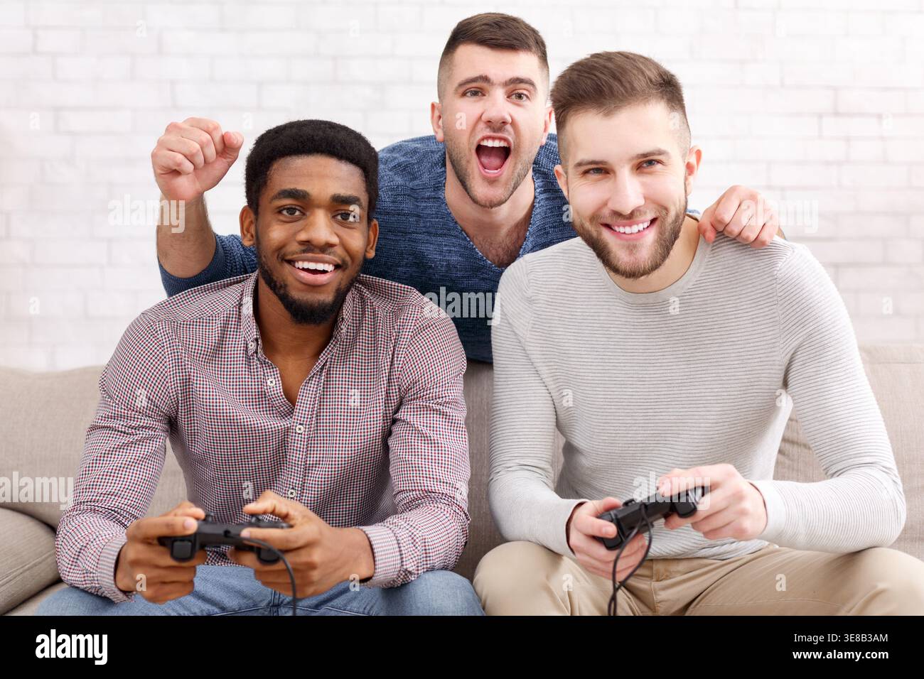 Giocatori. Uomini eccitati che giocano a videogame a casa Foto Stock