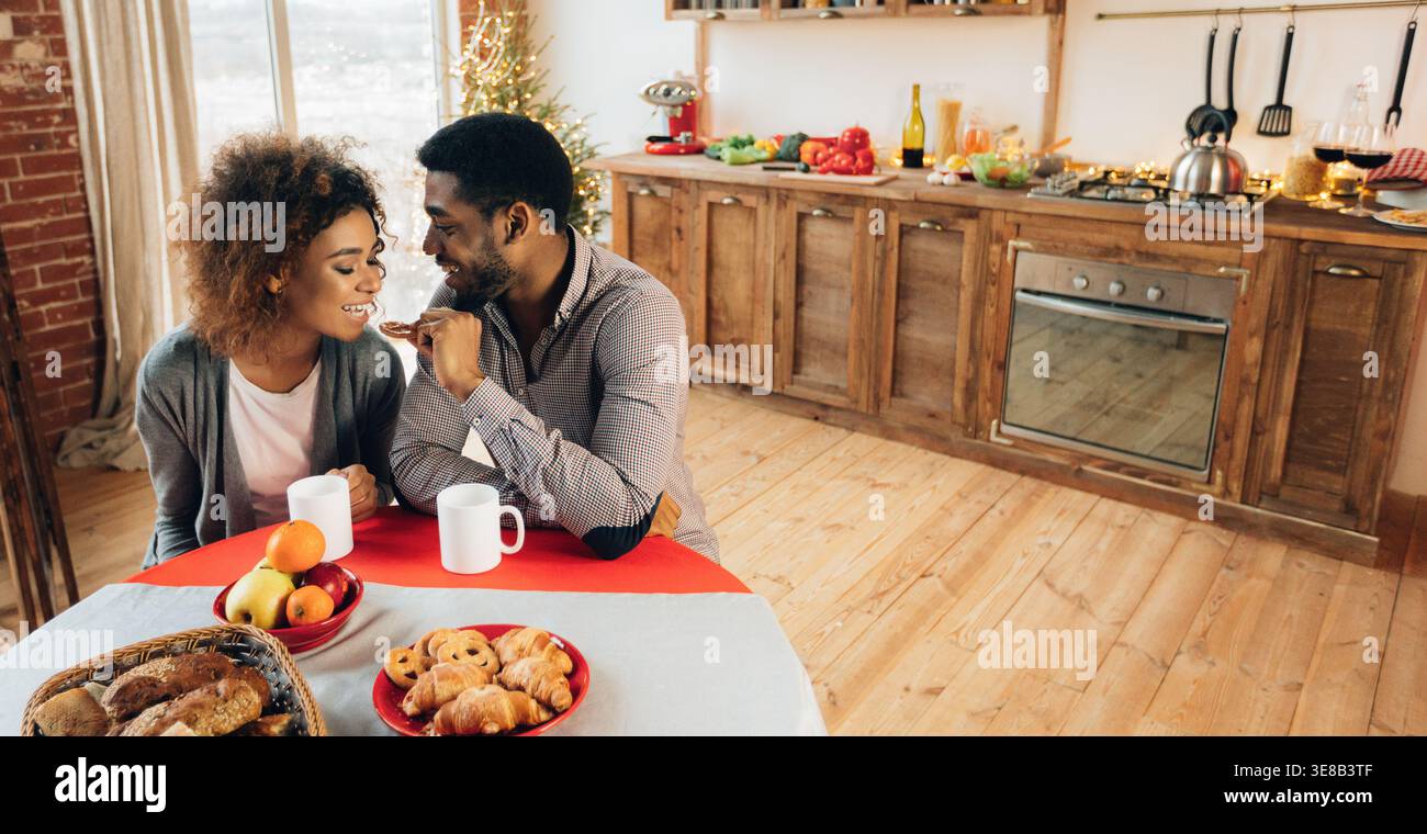 African-american giovane godendo gustosi biscotti in cucina Foto Stock