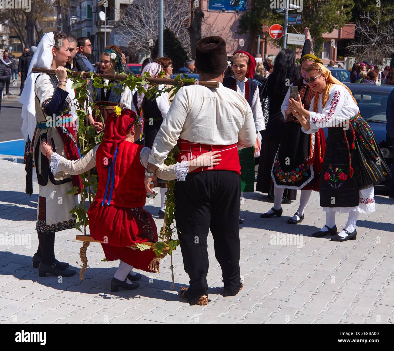 Pomorie, Bulgaria - 12 aprile 2026: I partecipanti ai tradizionali costumi bulgari celebrano la Pasqua in un festival folcloristico, caratterizzato da un abbigliamento colorato Foto Stock
