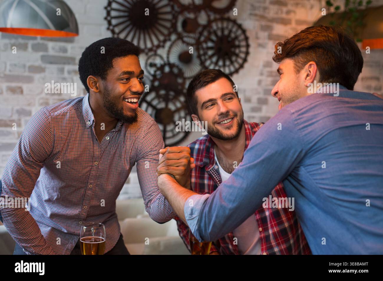 Diversi amici si incontrano, si salutano nel pub Foto Stock