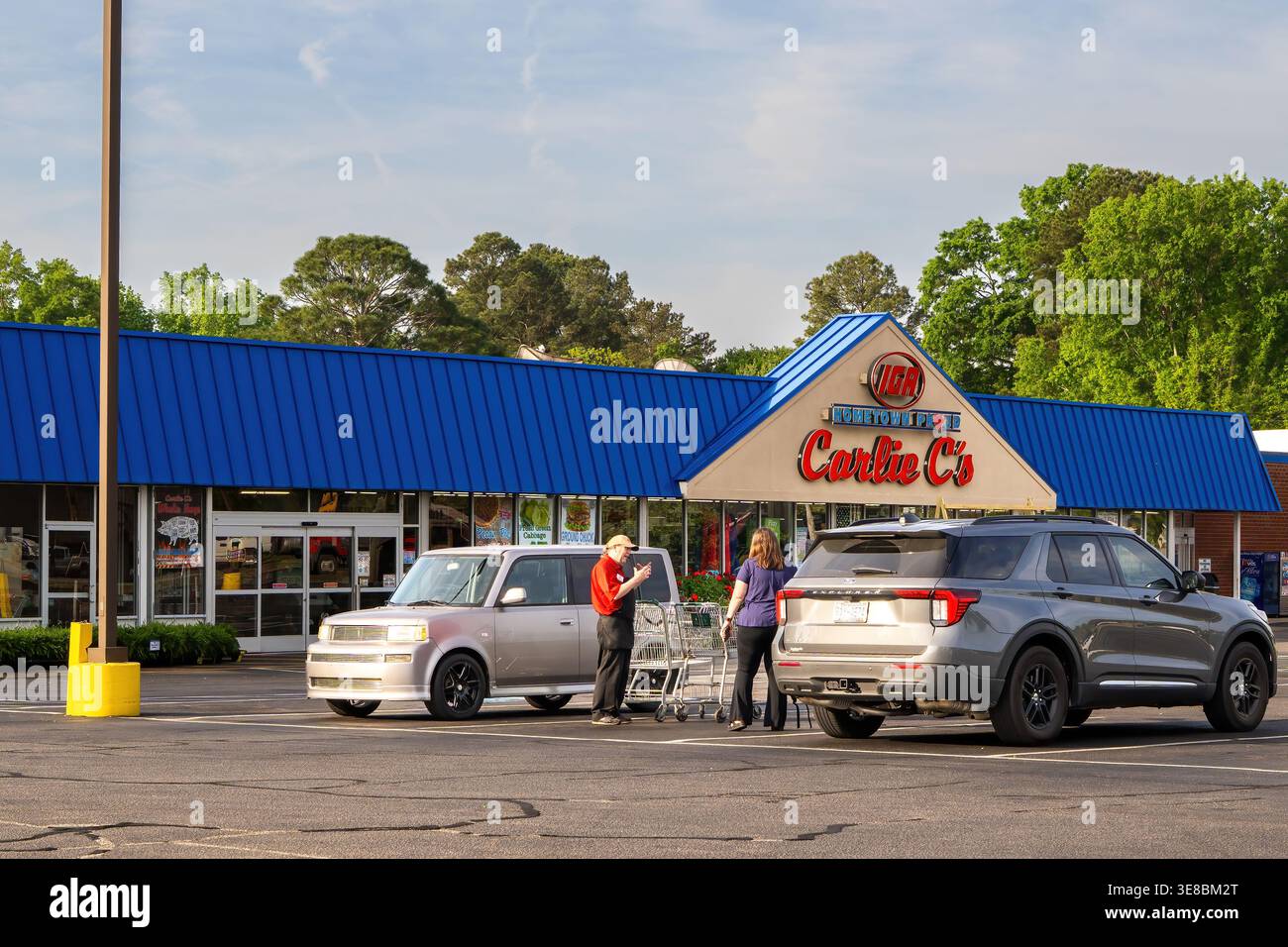Acquirenti con carrelli fuori dal negozio di alimentari IGA di Carlie C a Erwin, North Carolina, che illustrano la spesa dei consumatori e la vendita al dettaglio di piccole città. Foto Stock