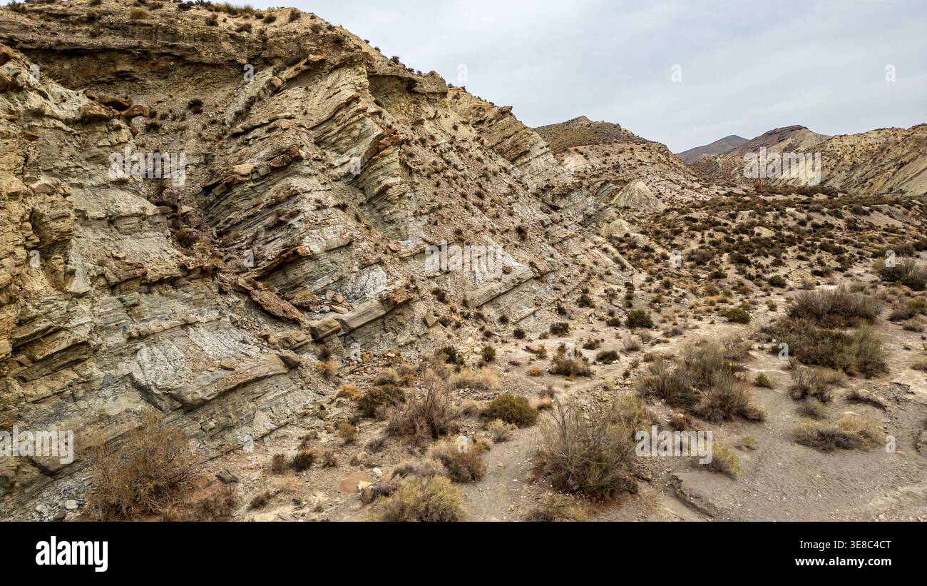 Splendida vista delle formazioni geologiche stratificate nel deserto di Tabernas. Ripidi calanchi e arida vegetazione mediterranea caratterizzano questo ru unico Foto Stock