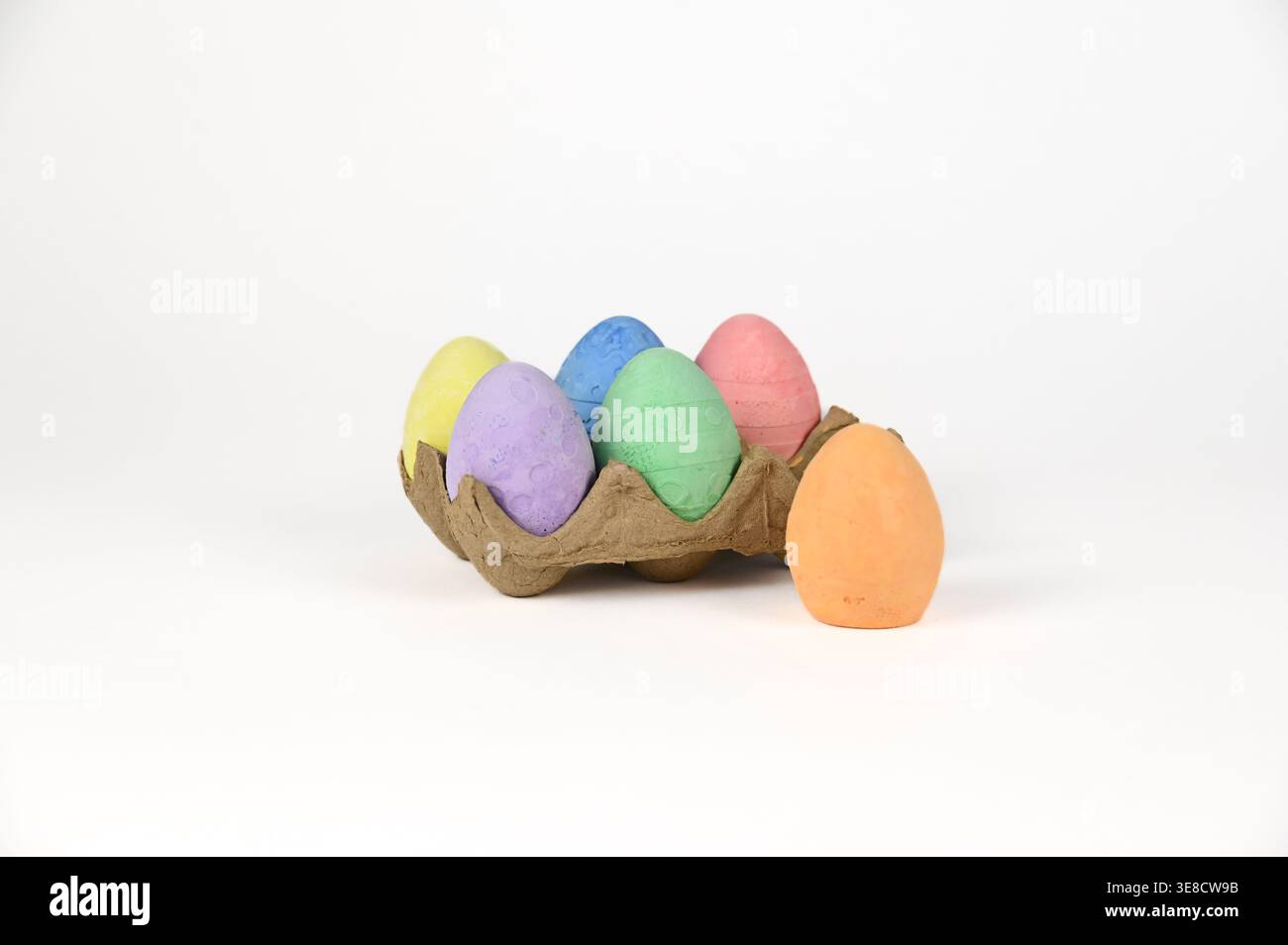 Cestino pasquale con vassoio di cartone contenente sei uova pasquali di gesso dai colori vivaci Foto Stock