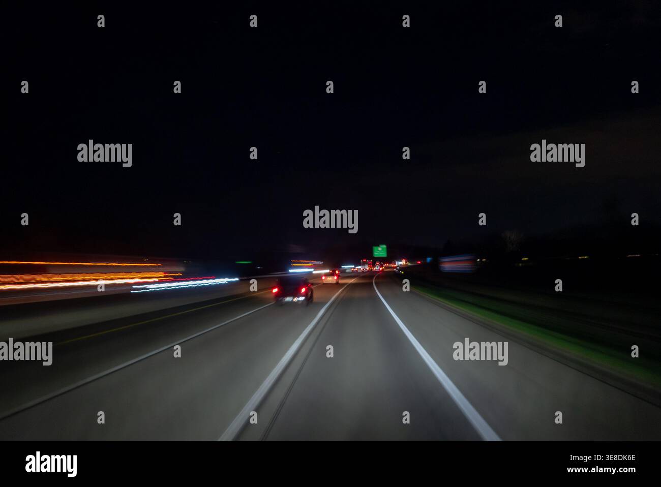 Guida in auto su un'autostrada di notte con sentieri leggeri Foto Stock