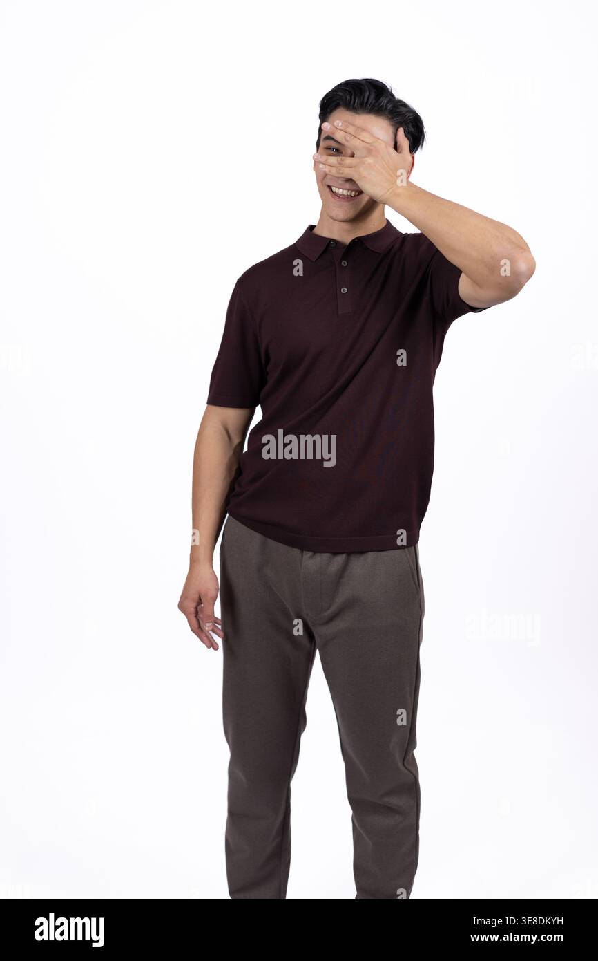 Uomo timido che si copre il viso con la mano nello studio Foto Stock