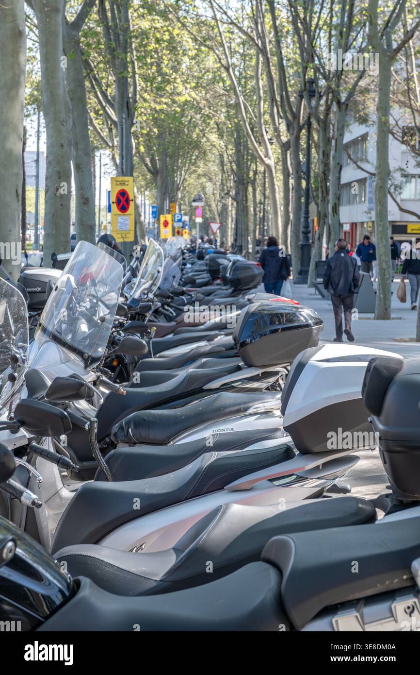 Lunga fila di motociclette parcheggiate sul marciapiede della città a Barcellona, Spagna, mobilità urbana e trasporti Foto Stock