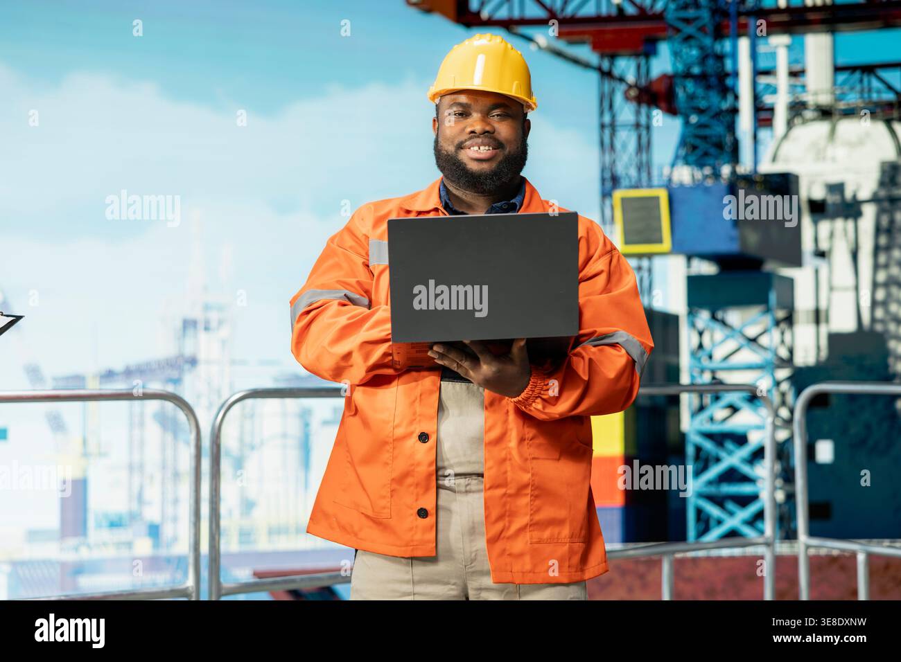 Ritratto dello specialista sorridente di piattaforme offshore supervisiona le operazioni di coperta, garantendo la conformità ai protocolli di sicurezza. Joyous man che lavora per un'azienda di gas esegue la manutenzione preventiva dei carri di perforazione Foto Stock