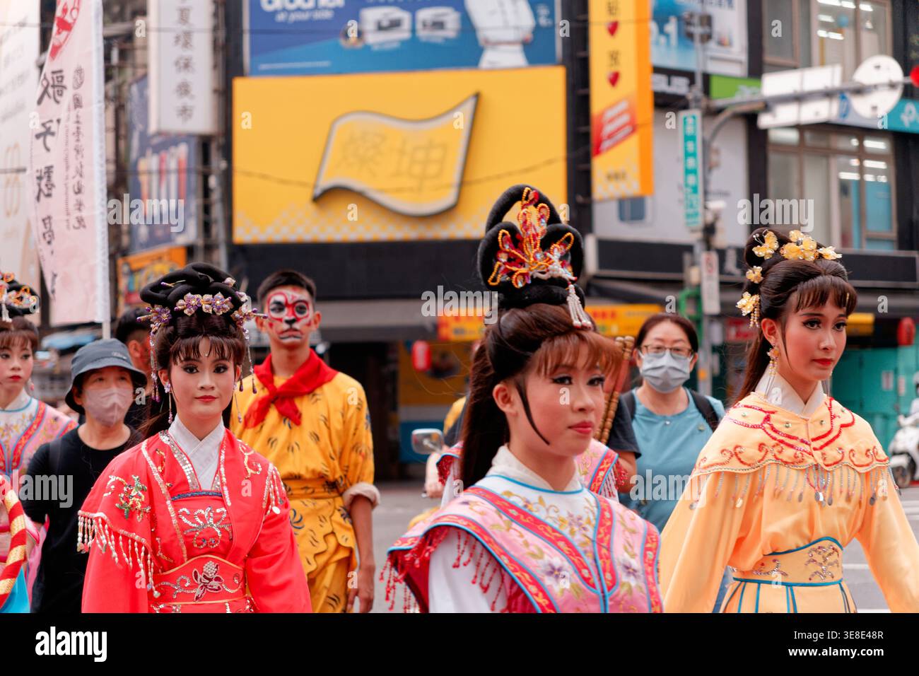 Taipei, Taiwan - 22 aprile 2024: Artisti dell'Opera in copricapi ornati e abiti ricamati marciano alla processione di pellegrinaggio del Tempio Baoan di Dalongdong. Foto Stock