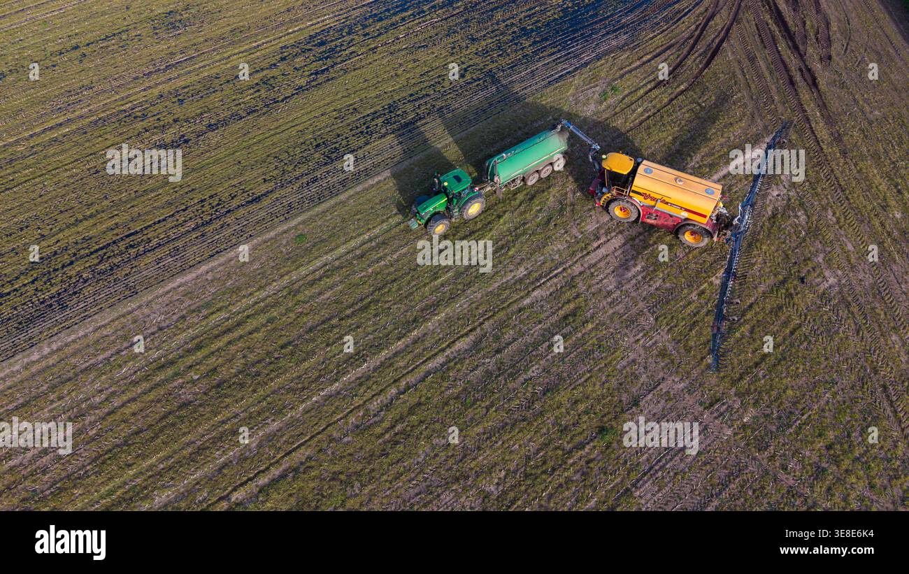 Vista aerea del trattore riempito dalla cisterna durante i lavori agricoli sul campo Foto Stock