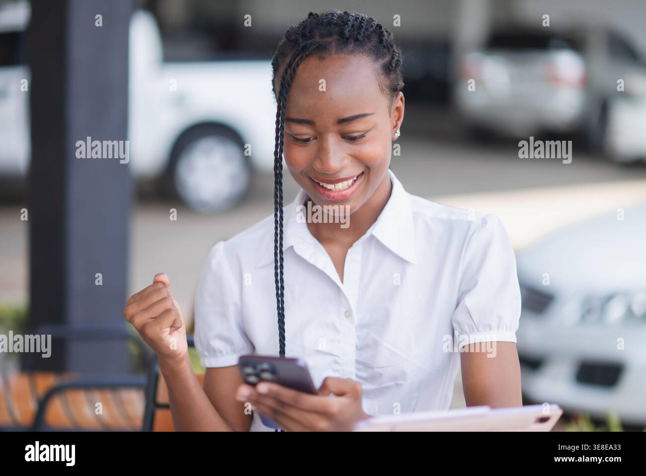 Giovane donna nera che festeggia mentre guarda un tablet sulle scale. Buone notizie, successo, apprendimento online, progressi aziendali, risultati digitali e depositi Foto Stock