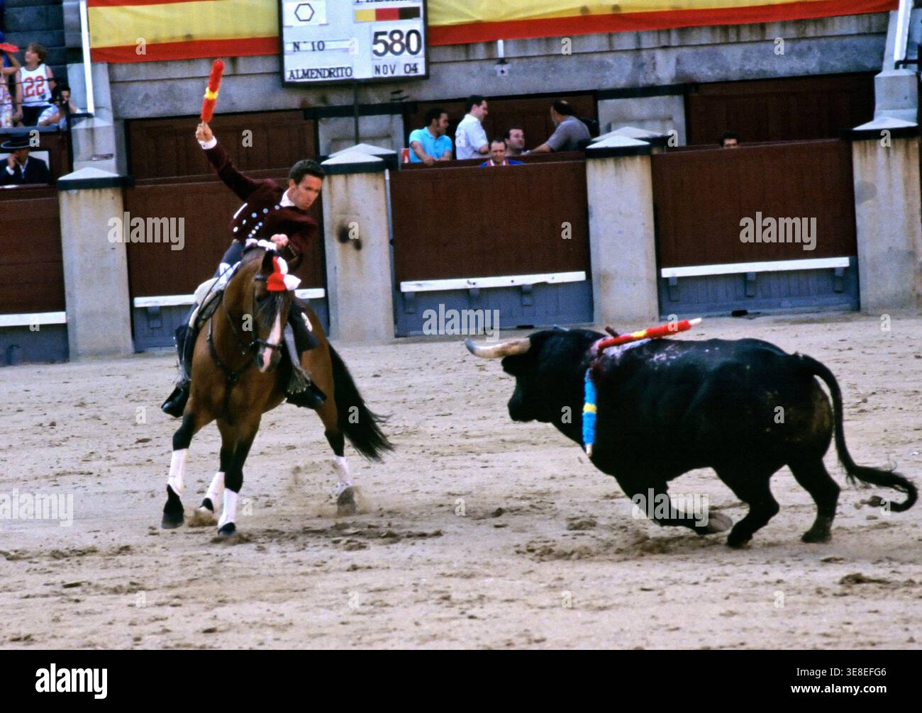Un torero a cavallo affronta un toro in un'arena a Madrid. La folla guarda come si svolge la lotta. Foto Stock